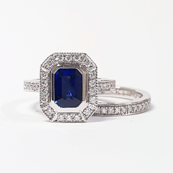 Emerald Cut Ceylon Sapphire in a Grain Set Halo Design Ring with Mill Grain Detail