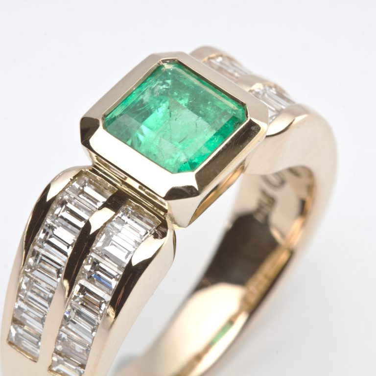 Emerald cut Emerald Bezel Set in a Yellow Gold Ring with Baguette Diamond Shoulders