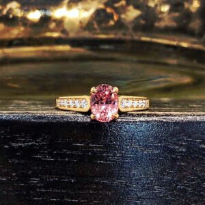 Yellow Gold Padparadscha Sapphire Ring with Diamonds Grain Set in the Shoulders.