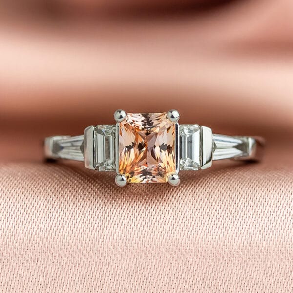 White gold engagement ring with peach sapphire and diamonds
