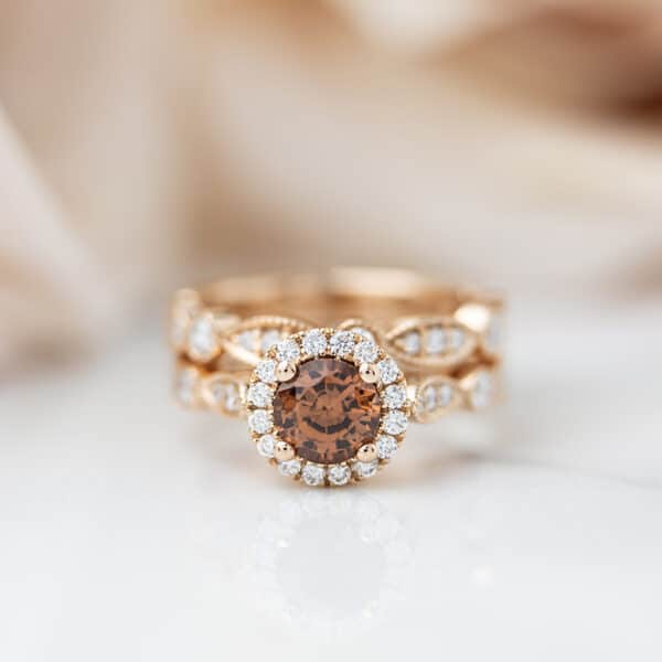 Peach tourmaline engagement ring with diamond halo and a scalloped diamond band
