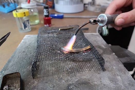 Couple heating gold to make their own wedding rings in the Larsen jewellery workshop
