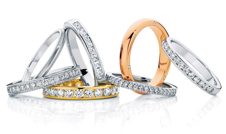 Stack of custom wedding rings in white gold, yellow gold, rose gold and platinum.