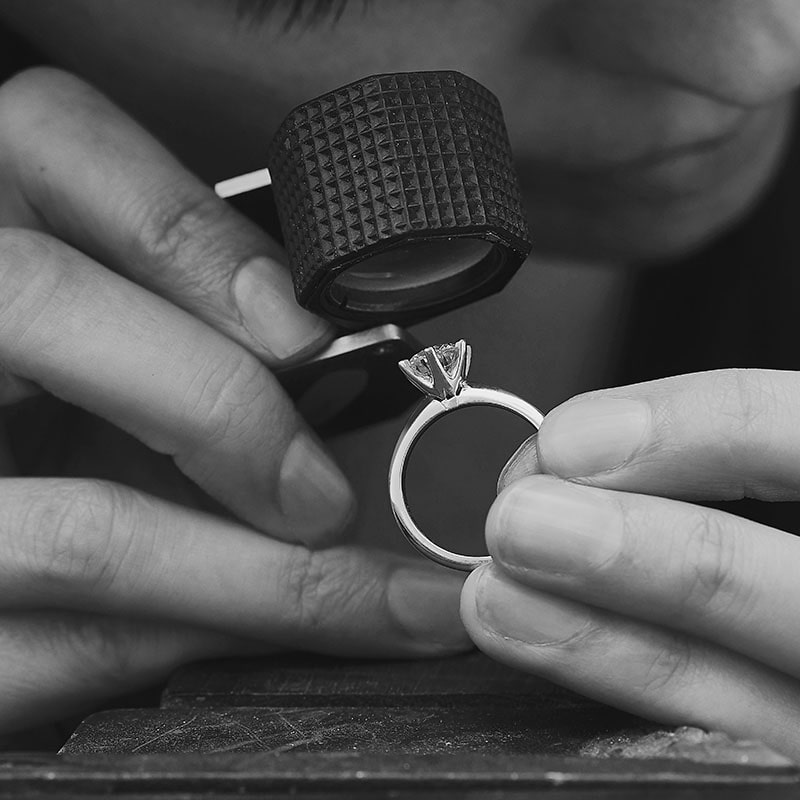 A jeweller inspects a diamond engagement ring