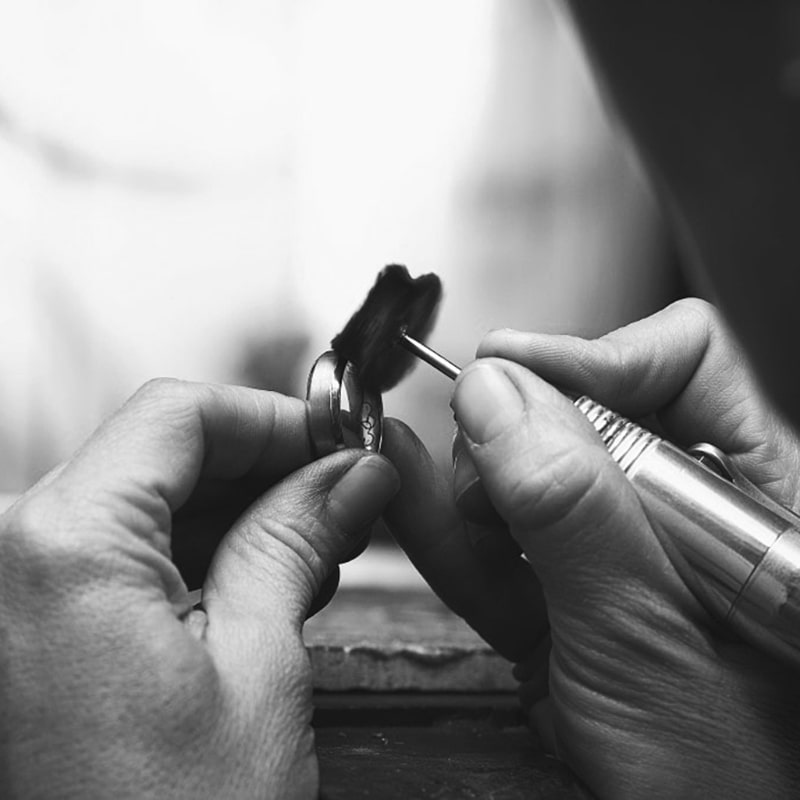 A jeweller polishing an 18ct gold wedding ring