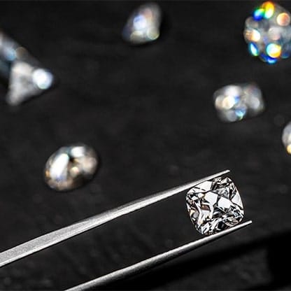 Cushion cut diamond in tweezers