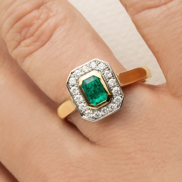 Emerald Cut Emerald Bezel Set in a Yellow Gold Ring with a White Gold Diamond Halo