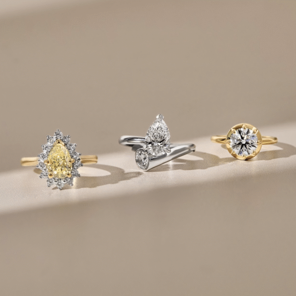 Yellow Pear Shaped Diamond with a Halo and Yellow Gold Band, Bypass Design Featuring Pear Shaped and Round Brilliant Cut Diamonds, Round Brilliant Cut Diamond with a Hybrid Bezel and Claw Setting