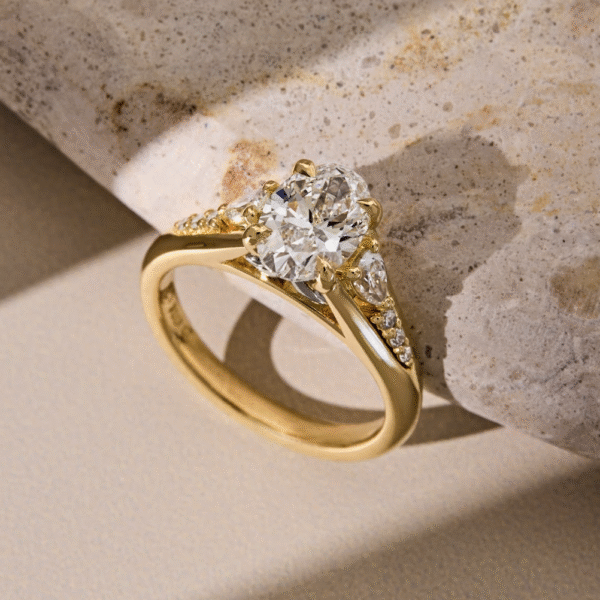 Oval Cut Diamond with Pear Shaped Side Stones and a Yellow Gold Band