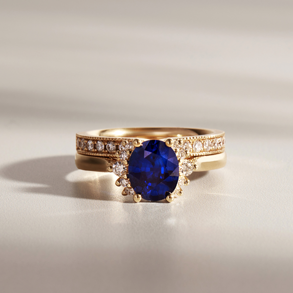 blue sapphire engagement ring with a 18ct yellow gold band and diamond wedding ring to match